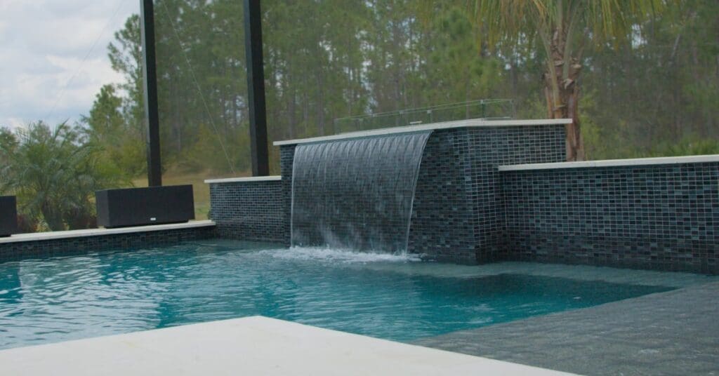 with a cascading waterfall gracefully pours into the pool below, adding both elegance and tranquility to the surroundings.